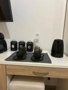 a table with two cups and a coffee maker on it at Rooms Marija in Malinska