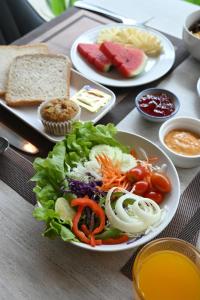 a table with two plates of salad and bread at C & N Hotel Patong, Phuket in Patong Beach +54 photos