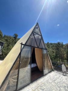 a glass dome tent with a bed in it at Forest Edge Hotel in Murree
