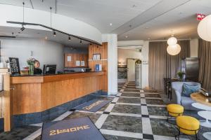 a lobby of a hotel with a counter and chairs at 2Home Hotel Apartments in Solna