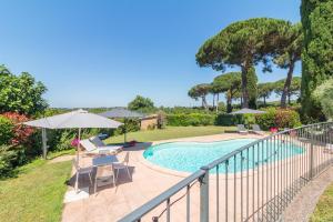 a swimming pool with chairs and umbrellas on a balcony at Ai due Cedri Appartamento Nocciolo in Capranica