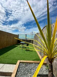 a patio with a table and a plant in a yard at Spacious Two Bed House With Stunning View. in Paull