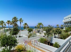 a view of a building with trees and plants at St George Beach Hotel & Spa Resort in Paphos