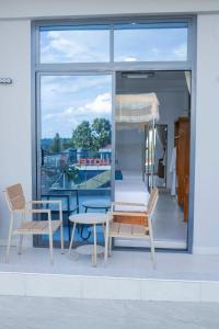 a patio with two chairs and a table and a window at The New Taiwan Hotel in Nyanhemwa