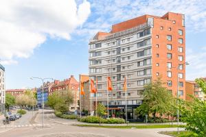 a building with flags in front of a street at 2Home Hotel Apartments in Solna