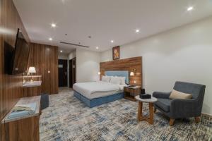 a hotel room with a bed and a chair at Sidra Serviced Apartments - سدرا للشقق المخدومة in Al Khobar +89 photos