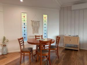 a dining room with a table and chairs and stained glass windows at The Panorama On Earl in Albany