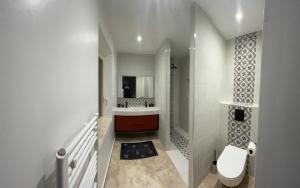 a white bathroom with a toilet and a sink at Les Cachots in Roussillon