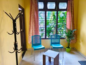 a room with two chairs and a window at Mon Aashray Stay in Guwahati
