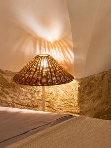 a lamp sitting next to a bed in a room at Pètra Boutique Home by Symphonya Luxury Holiday Rentals in Scorrano +10 photos