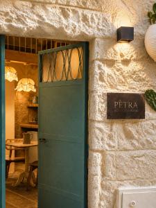 a green door with a sign on a wall at Pètra Boutique Home by Symphonya Luxury Holiday Rentals in Scorrano