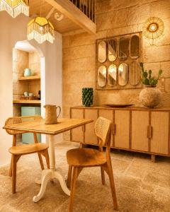 a kitchen with a wooden table and chairs at Pètra Boutique Home by Symphonya Luxury Holiday Rentals in Scorrano