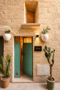 a building with a green door and cactus at Pètra Boutique Home by Symphonya Luxury Holiday Rentals in Scorrano