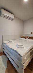 a bedroom with a large bed with white sheets at Apartmán GIGI Rezort Linea in Piešťany +17 photos