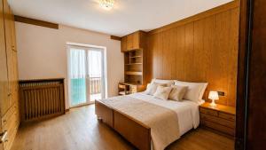 a bedroom with a large bed and a window at Appartamento Graziella in Castello di Fiemme