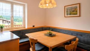 a dining room with a table and a couch at Appartamento Graziella in Castello di Fiemme