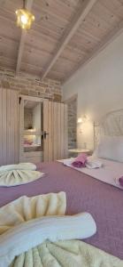 a large bedroom with two beds with purple sheets at Villa Efthalia in Pitsidia