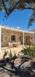 a stone house with a white pergola at Villa Efthalia in Pitsidia