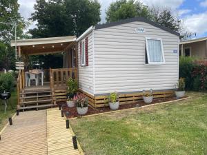 a tiny house with a porch and a deck at L'échapée verte in Litteau
