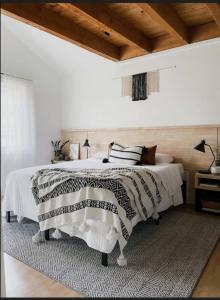 a white bedroom with a bed with a rug at 4cs apartment in Bayanan