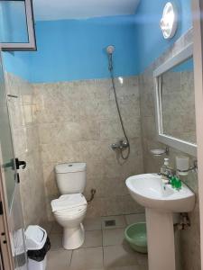 a bathroom with a toilet and a sink at Emy's Rooms in Himare +37 photos