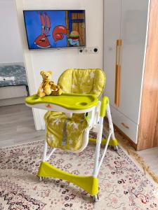a yellow chair with a teddy bear sitting on it at Sunrise House in Cholpon-Ata
