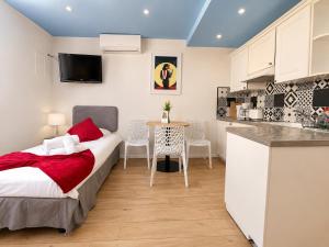 a bedroom with a bed and a kitchen with a table at Hotel Le Florian in Cannes