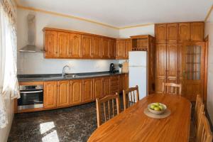 a kitchen with wooden cabinets and a table with a bowl of fruit at Naomi’s House in Fasnia