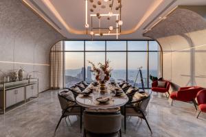 a dining room with a table and chairs and a large window at Hampton Sriracha in Si Racha