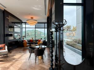 a living room with a mirror and a table and chairs at Hampton Sriracha in Si Racha