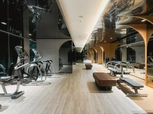 a gym with treadmills and ellipticals in a building at Hampton Sriracha in Si Racha