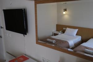 a reflection of a bedroom with a bed and a mirror at Üstün Hotel Alsancak in İzmir