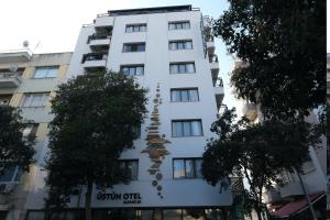 a white building with a sign on the side of it at Üstün Hotel Alsancak in İzmir +17 photos