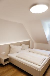 a white bed in a room with a white ceiling at Zur Pfanne – Studio in Biberach an der Riß