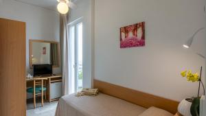 a room with a bed and a desk and a window at Baby Gigli in Numana