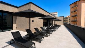 a row of chairs with umbrellas on a building at Hotel PALAZZO PEPE & JACUZZI in Naples