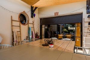 a dining room with a wooden table and a glass door at Tomland in Parentis-en-Born