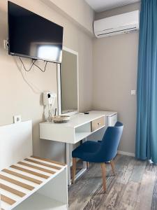 a bedroom with a desk and a blue chair at Hotel ADMIRAL POTOS THASSOS in Potos