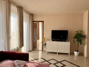 a living room with a television on a dresser at Gruber Apartman in Siófok