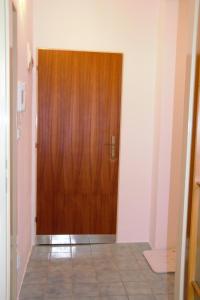 a wooden door in a hallway with a tile floor at Apartment Lazovná in Banská Bystrica