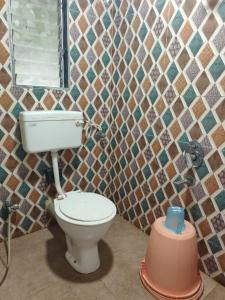 a bathroom with a toilet in a tiled wall at Hotel Garden View - Andheri West in Mumbai