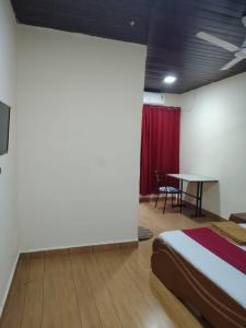 a bedroom with a bed and a table in a room at Hotel Garden View - Andheri West in Mumbai +15 photos