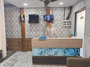 a man standing behind a counter in a room at Hotel Garden View - Andheri West in Mumbai