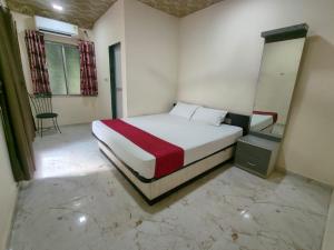 a bedroom with a bed and a chair in it at Hotel Garden View - Andheri West in Mumbai