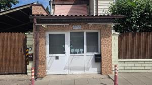 a white door on a house with a fence at ApartHotel SAVAS 1 Mini Studio and parking in Kaunas