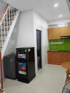 a kitchen with a black refrigerator and a staircase at Phú Hưng Gia Motel in Ðức Hòa +6 photos