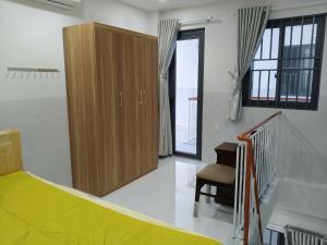 a bedroom with a bed and a cabinet and a chair at Phú Hưng Gia Motel in Ðức Hòa