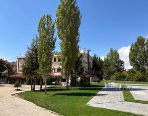 a park with tables and trees in front of a building at Mon Refuge 120 in Bcharré