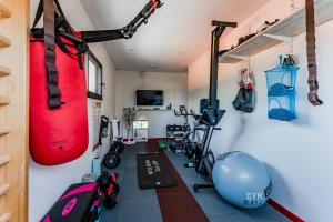 a room with a gym with a punching bag and weights at Tomland in Parentis-en-Born