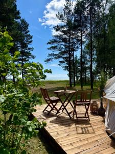 a wooden deck with a table and two chairs at Mändjala Glamping in Mändjala